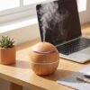 Home fragrance diffuser on a desk next to a laptop for a calm workspace